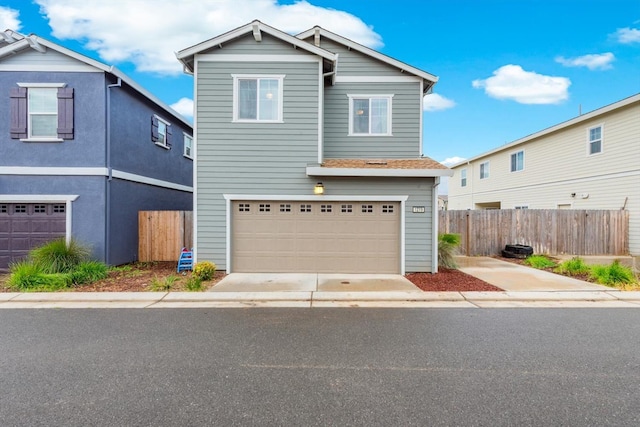 traditional home featuring fence, driveway, and a garage