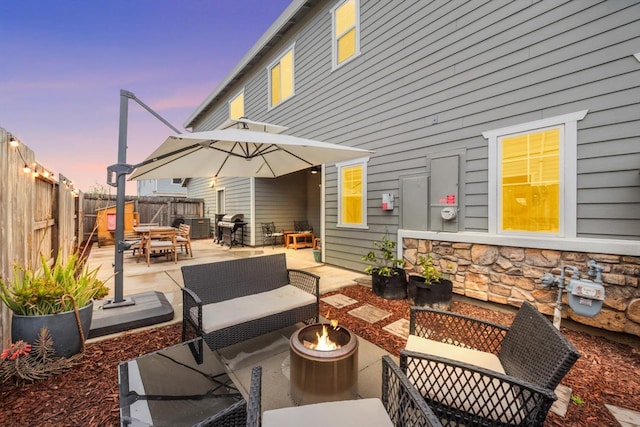 view of patio / terrace featuring a grill, a fenced backyard, outdoor dining space, and an outdoor living space with a fire pit