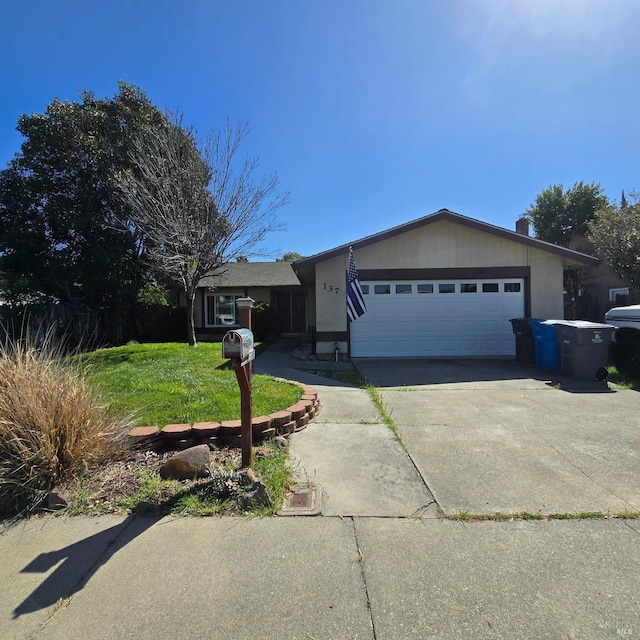 view of front facade with a front yard, an attached garage, and concrete driveway