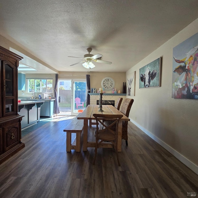 dining space featuring baseboards, dark wood-style flooring, ceiling fan, and a textured ceiling