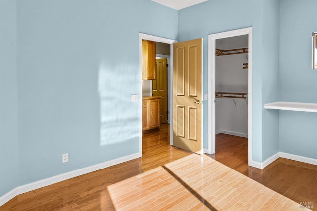 2909 Quail Hollow Dr, Fairfield, CA 94534 - unfurnished bedroom with baseboards, a walk in closet, and wood finished floors