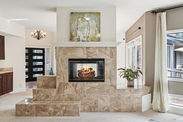living room with an inviting chandelier, a tile fireplace, and light colored carpet