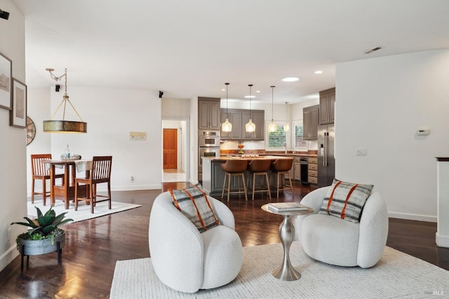 living room featuring dark wood finished floors, baseboards, visible vents, and recessed lighting