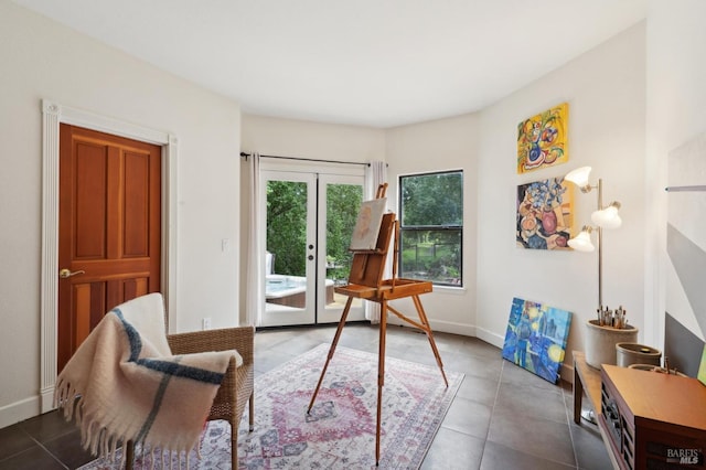 living area featuring baseboards, french doors, and tile patterned floors