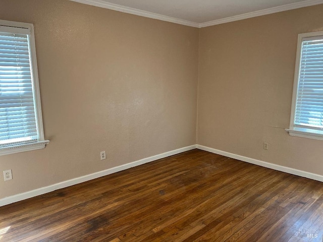 spare room with baseboards, ornamental molding, and dark wood-type flooring
