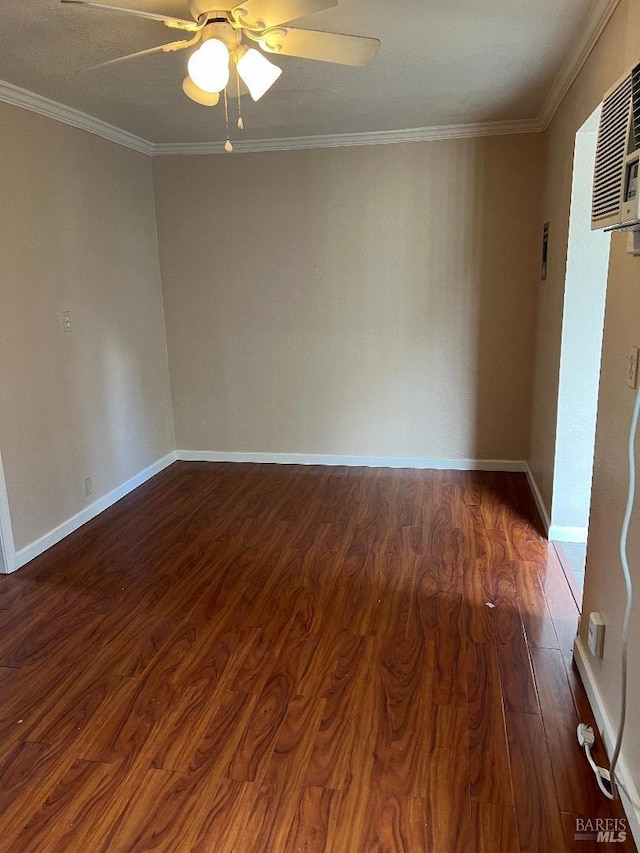 spare room featuring baseboards, ornamental molding, ceiling fan, and dark wood finished floors