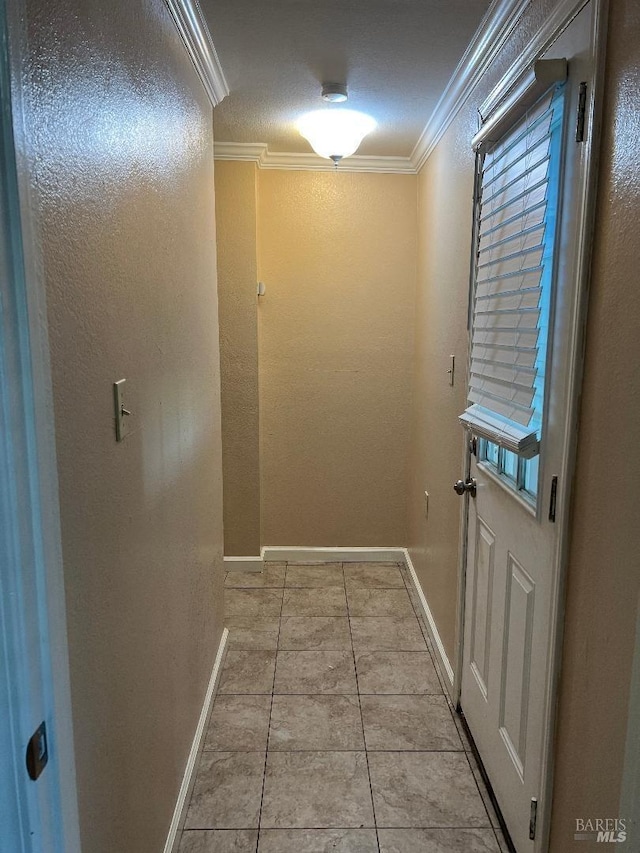 entryway with baseboards, tile patterned flooring, and ornamental molding