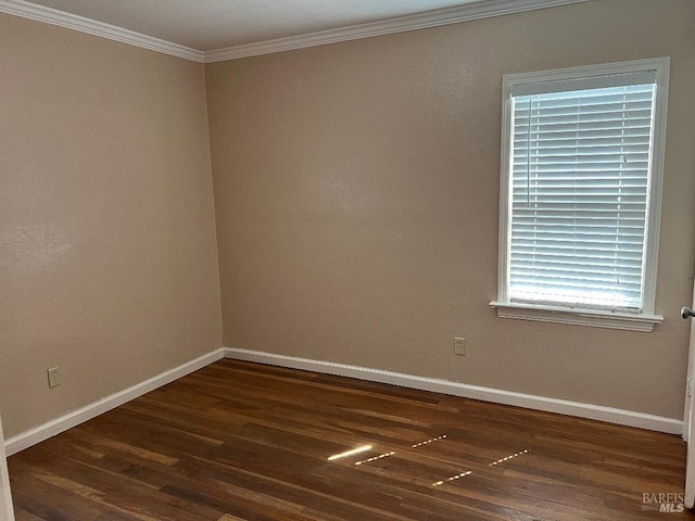 spare room featuring baseboards, ornamental molding, and wood finished floors