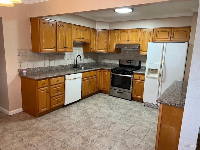 kitchen featuring white appliances, under cabinet range hood, backsplash, a sink, and brown cabinetry