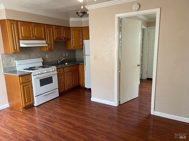 kitchen featuring ornamental molding, dark wood-type flooring, under cabinet range hood, and white appliances