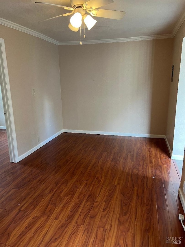 empty room featuring baseboards, dark wood-style floors, ceiling fan, and ornamental molding