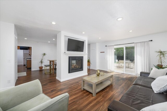 living area featuring baseboards, wood finished floors, and wallpapered walls
