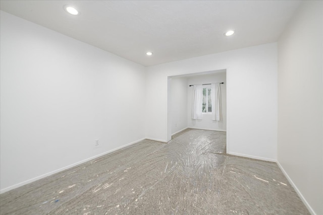 carpeted empty room featuring baseboards and recessed lighting