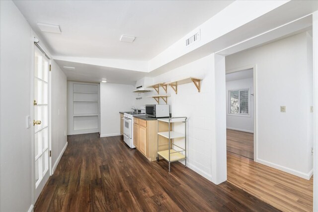 kitchen with stainless steel microwave, light brown cabinets, white gas range oven, open shelves, and dark wood finished floors