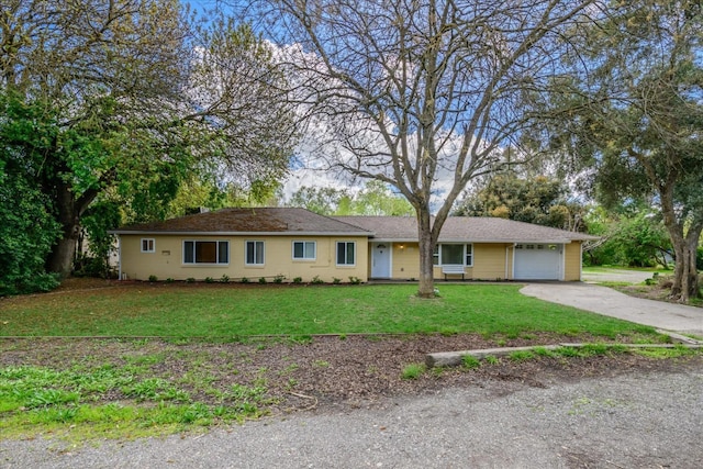 single story home featuring a front lawn, a garage, and driveway