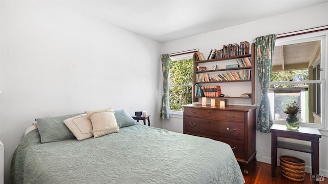 bedroom featuring baseboards and dark wood-type flooring