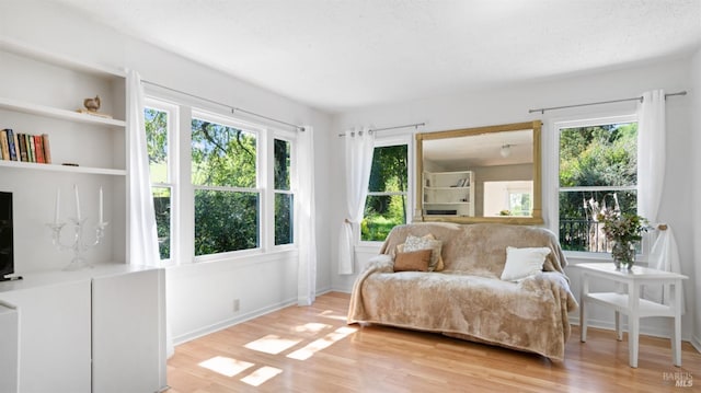 living area featuring light wood-style floors and baseboards