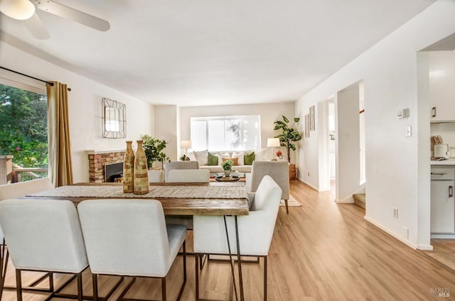 361 Neva St, Sebastopol, CA 95472 - dining space with light wood finished floors, a brick fireplace, a ceiling fan, and a healthy amount of sunlight