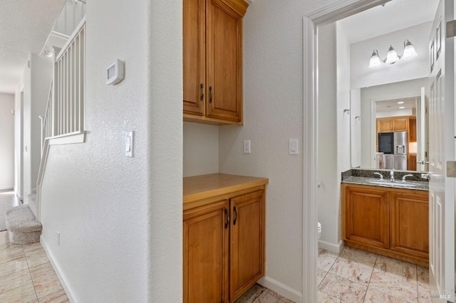 interior space featuring brown cabinets, baseboards, and a sink