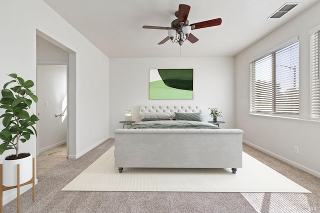 bedroom with light colored carpet, visible vents, ceiling fan, and baseboards