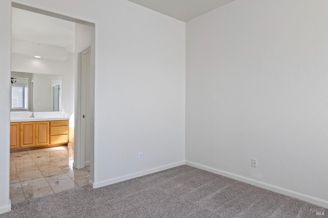 spare room featuring baseboards and light colored carpet