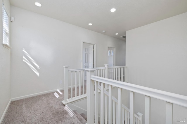 hallway featuring baseboards, an upstairs landing, carpet floors, and recessed lighting