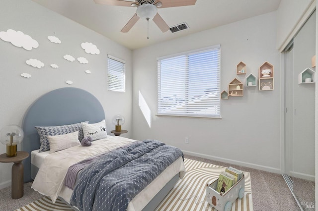 carpeted bedroom with baseboards, visible vents, and a ceiling fan