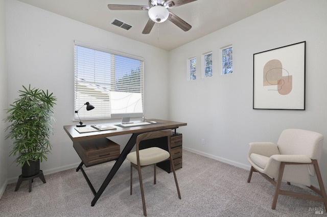 office space featuring a ceiling fan, light carpet, baseboards, and visible vents