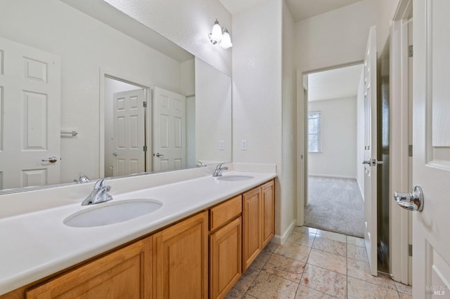 full bathroom with baseboards, double vanity, and a sink
