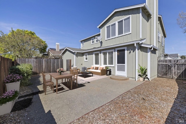 rear view of property with a fenced backyard, an outdoor living space, a patio, and board and batten siding