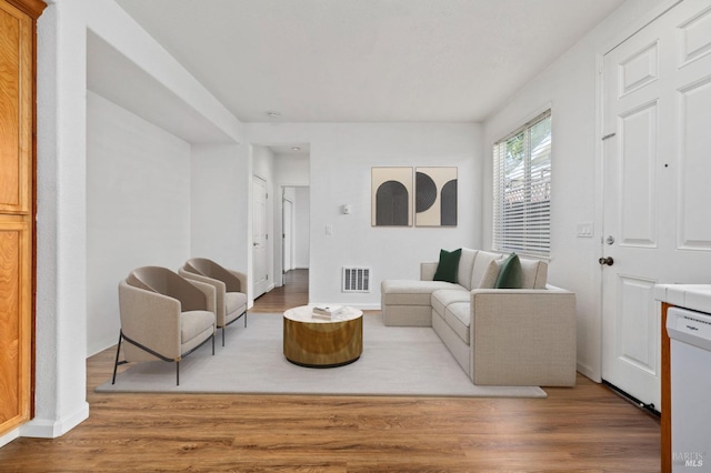 living area featuring baseboards, visible vents, and wood finished floors