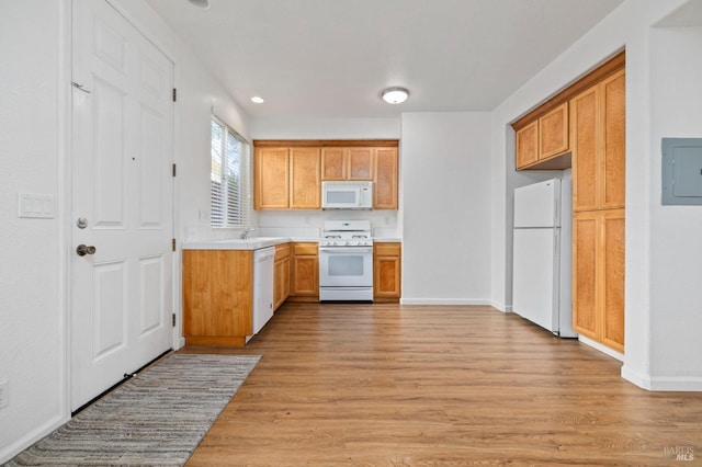 kitchen with light countertops, electric panel, white appliances, baseboards, and light wood-style floors