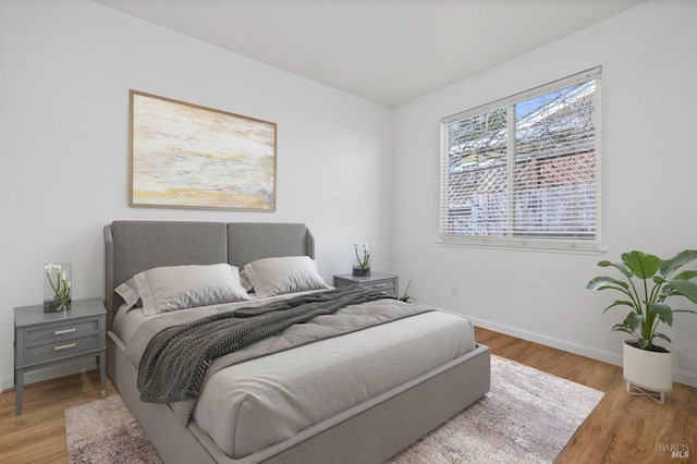 bedroom featuring baseboards and wood finished floors