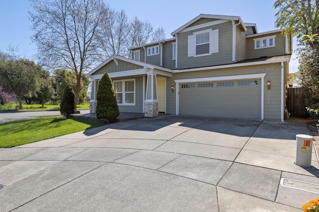 craftsman inspired home with a garage, concrete driveway, and fence