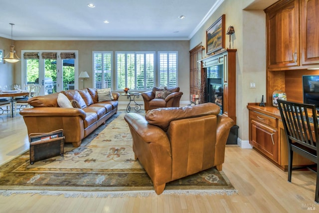living area featuring crown molding, recessed lighting, baseboards, a high end fireplace, and light wood-style flooring