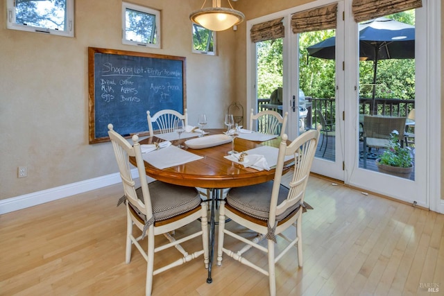 dining space featuring baseboards, wood finished floors, and french doors
