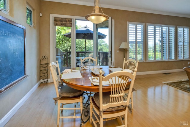 dining area featuring ornamental molding, baseboards, and wood finished floors