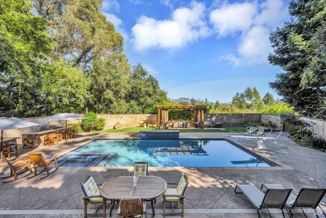 view of swimming pool featuring outdoor dry bar, a patio, a fenced backyard, a fenced in pool, and a pergola