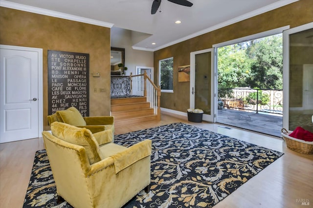 living room with a ceiling fan, ornamental molding, a healthy amount of sunlight, and wood finished floors
