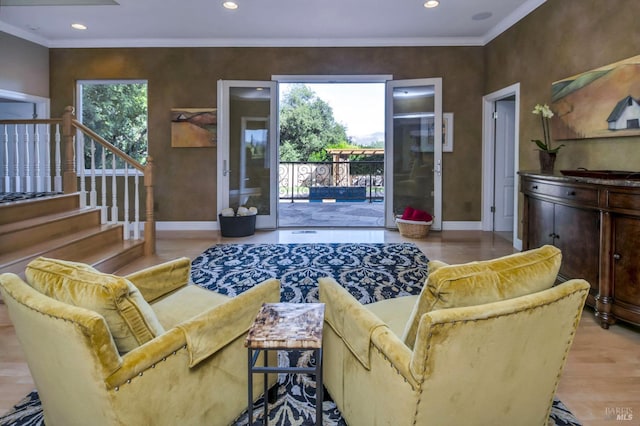 living area with baseboards, crown molding, and plenty of natural light