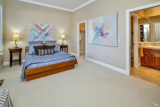 bedroom with baseboards, ornamental molding, light carpet, a sink, and a walk in closet
