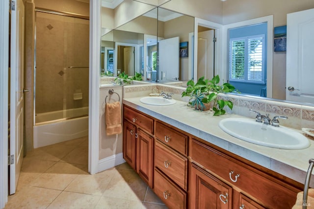bathroom with double vanity, a sink, tile patterned flooring, and enclosed tub / shower combo