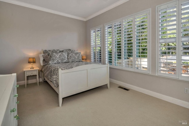 bedroom featuring light carpet, crown molding, baseboards, and visible vents