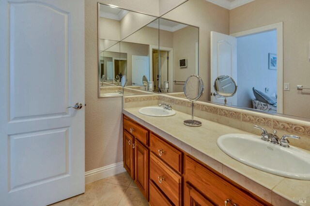 full bath featuring double vanity, a sink, tile patterned flooring, and crown molding