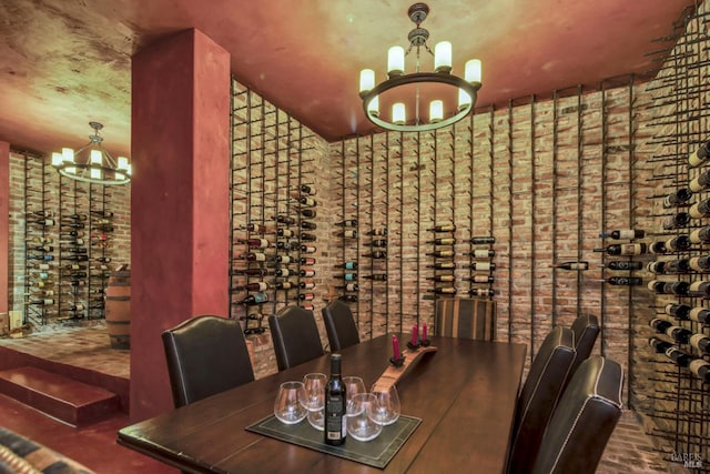 wine room with brick floor, a chandelier, and brick wall