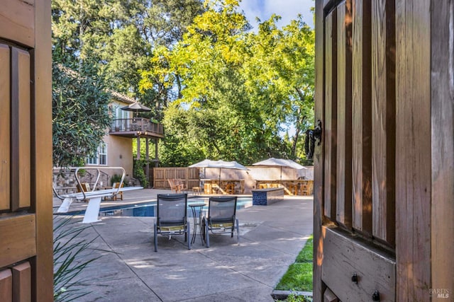 view of patio featuring outdoor dining area, fence, and a fenced in pool