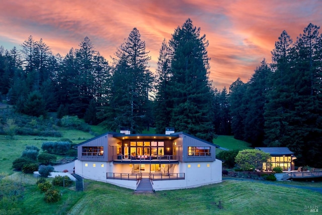 back of house featuring a deck and a lawn
