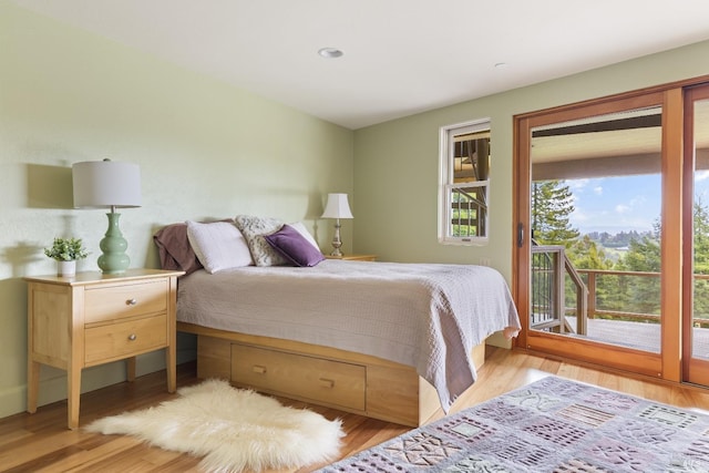 bedroom with access to outside and wood finished floors
