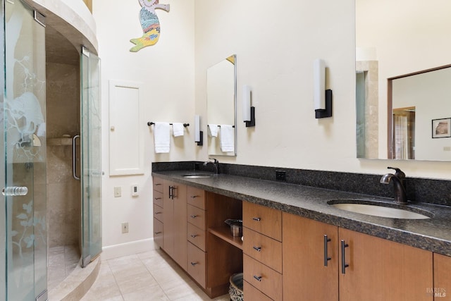 full bathroom with a sink, tile patterned floors, double vanity, and a stall shower