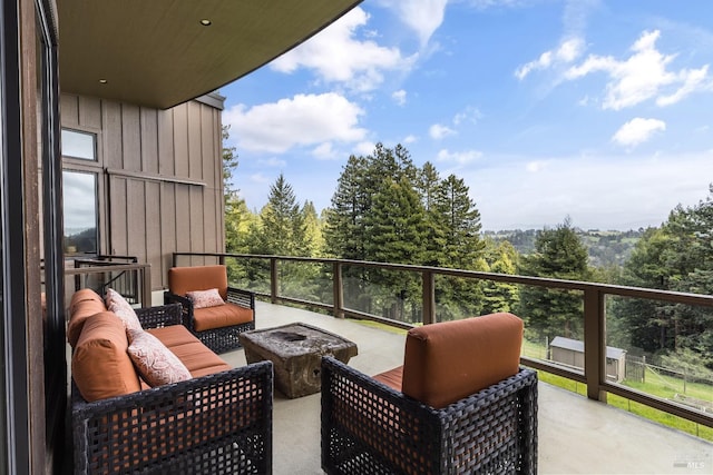 balcony featuring an outdoor living space with a fire pit